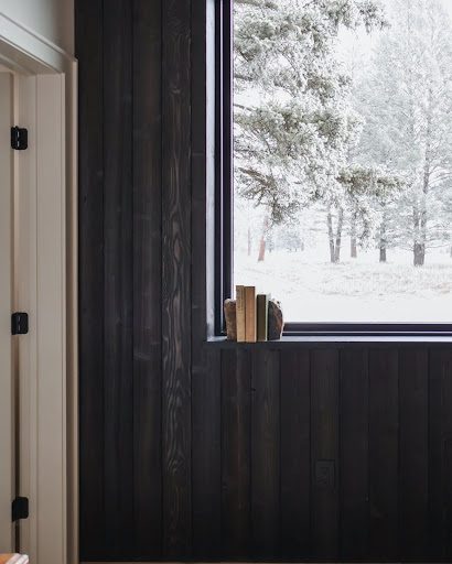 This image shows a home office featuring a wood accent wall made of Timber Forge Black Forest Cedar. The rich, dark wood grain adds warmth and texture, complementing the decor with an elegant touch.
