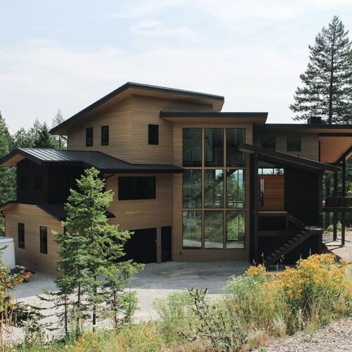 Replacing wood siding on a luxury multi-story home brings a bold contrast against the black trim